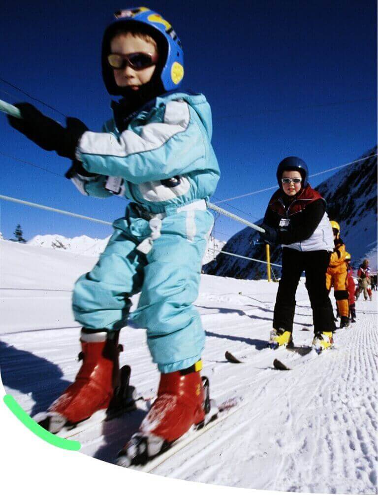 groupe de personnes utilisant les tires fesses sur une piste de ski eneigé